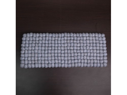 Rectangular grey wool felt ball cat mat on table background